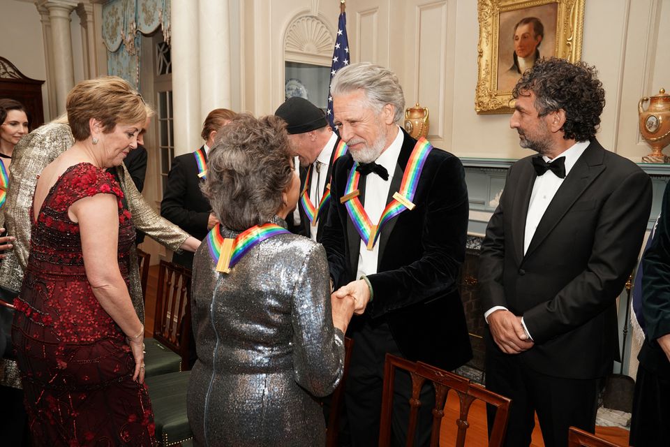 Kennedy Center honorees U2 band member Adam Clayton greets Cuban-born American composer, conductor and educator Tania Leon during a reception for Kennedy Center honorees ahead of the official gala at the State Department in Washington, D.C., U.S., December 3, 2022. REUTERS/Sarah Silbiger